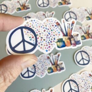 Artsy die-cut gloss vinyl sticker with cozy colours and art supplies, peace love art