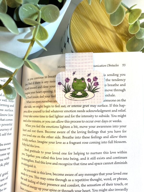 Cute kawaii frog sitting on a lily pad with flowers on a pink and white plaid background